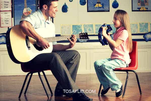 teacher teaching guitar to a girl