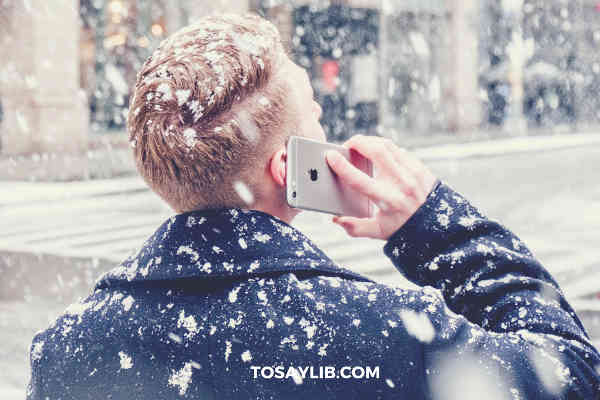 white man talking on iphone snowing