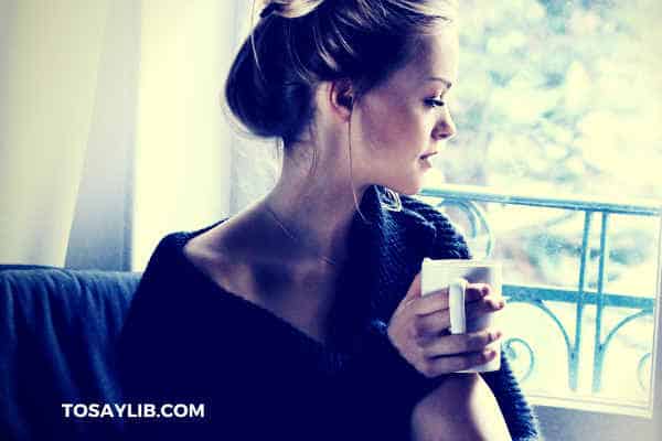 pretty girl drinking coffee looking out of window