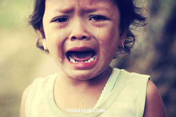 little girl crying out loud on street