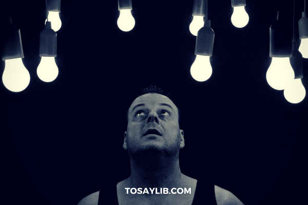 performer looking at light bulbs