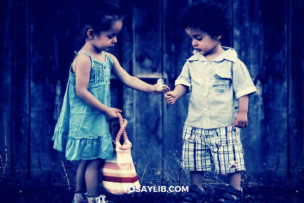 little girl giving flowers to little boy