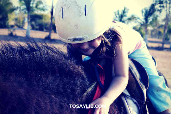 little girl riding on a pony