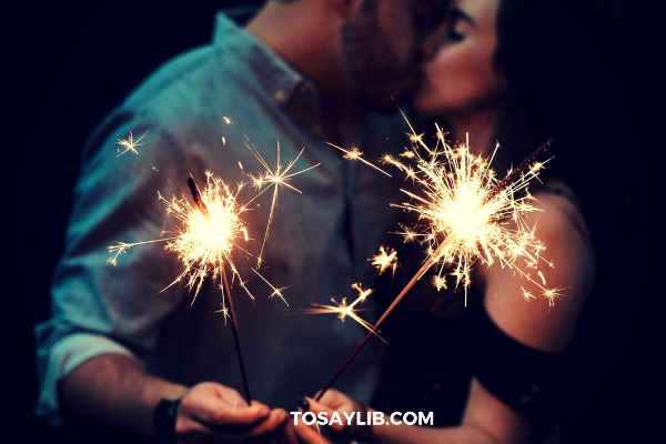 couples kissing holding firework sticks