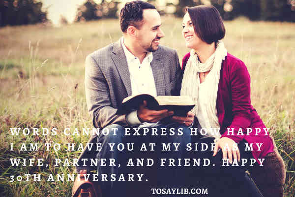 couples smilimg reading a book on the field