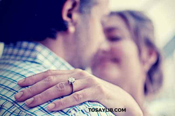 couple hugging dancing with a ring on her finger