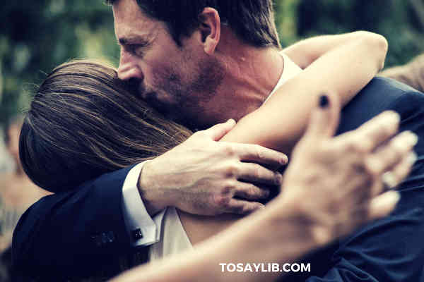 dad hugging kissing adult daugther