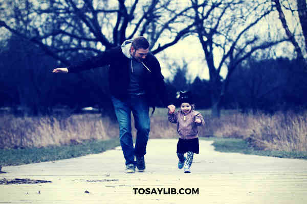 dad having a walk with daughte in a park