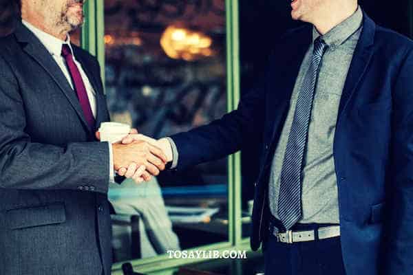 boss shake hands with staff holding coffee