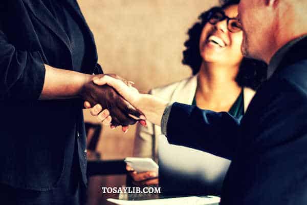 colleagues shake hands laughing