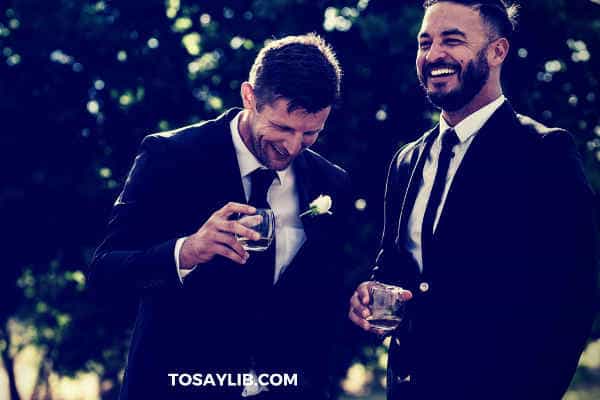 two best men laughing watching drinking