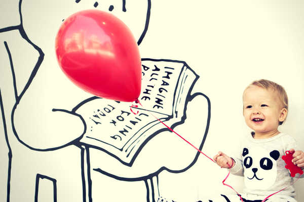 baby red birthday ballon against wall gingerman in chair