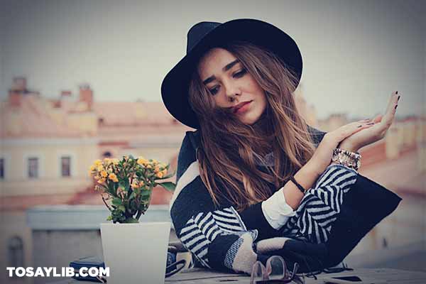 01 fashionable woman with a hat sitting outdoors