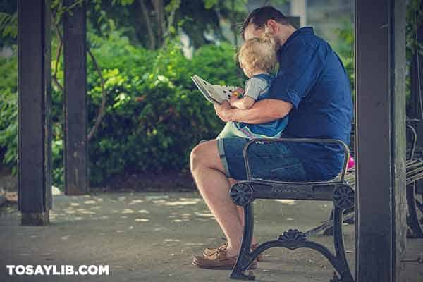 10 Man with kid sitting on a bench in the park