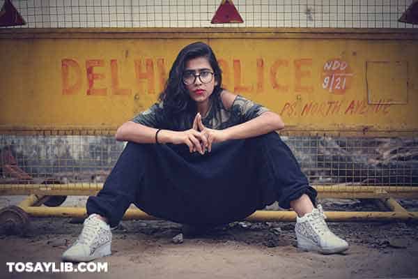 01 Full portrait photo of a woman sitting on the ground looking serious