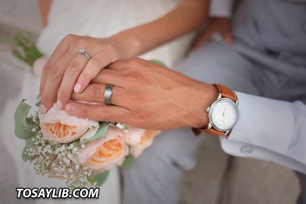 10 Photo of a couples hands on top of each other holding a bouquet of flowers