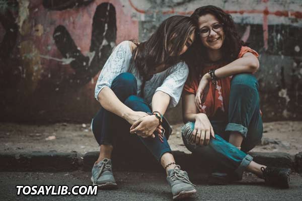 Photo of two friends sitting together happily.