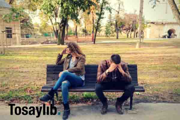 woman and man sitting on brown wooden bench argument