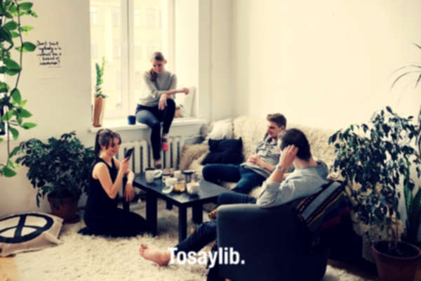 people gathered inside house sitting on sofa white carpet