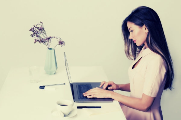 05-feature-woman-in-pink-dress-using-laptop-computer-coffee-vase-white