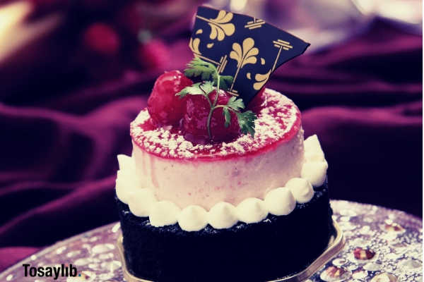 chocolate cake with white icing and strawberry on top with chocolate