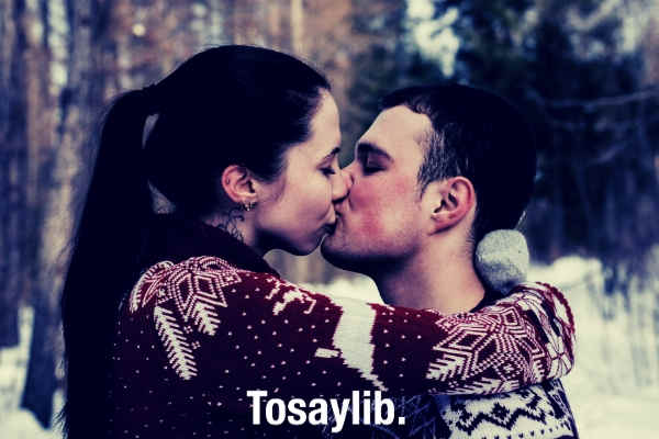 couple-kissing-each-other-sweater-snow-trees