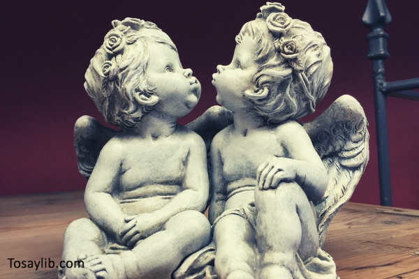 angels sculpture statue cherub staring up red wall