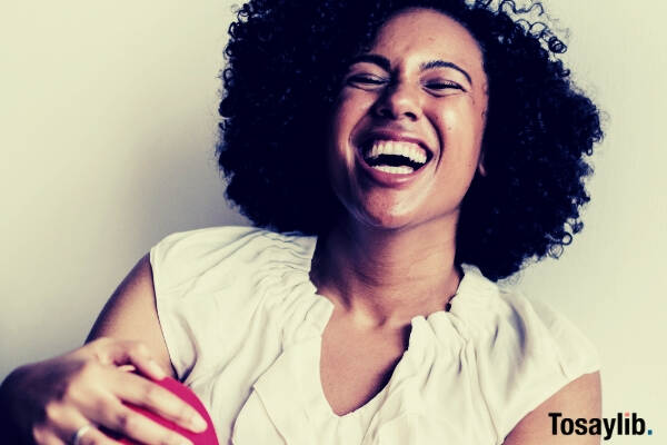 woman wearing white sleeveless top and red bottoms laughing