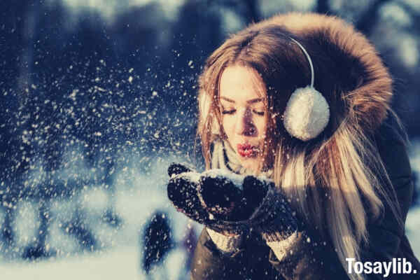 adult beautiful christmas cold woman blowing snow