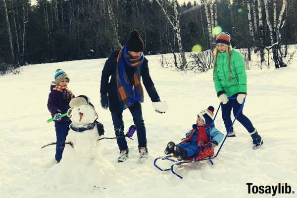 four persons playing on snow