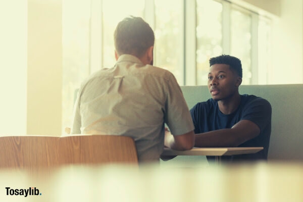 01 two men talking sitting black american