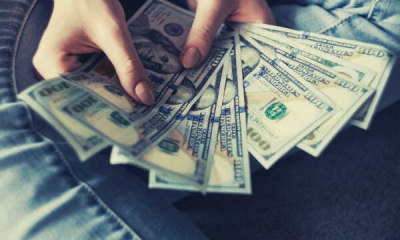featur-person-holding-100-us-dollar-banknotes