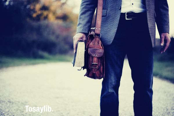 man wearing suit leather bag holding book v2