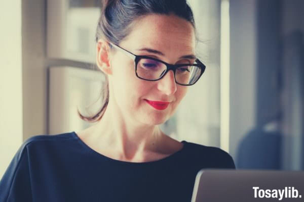 woman in black wearing black eyeglass looking at the screen 1