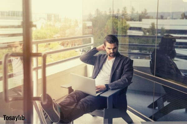 man sitting while using laptop