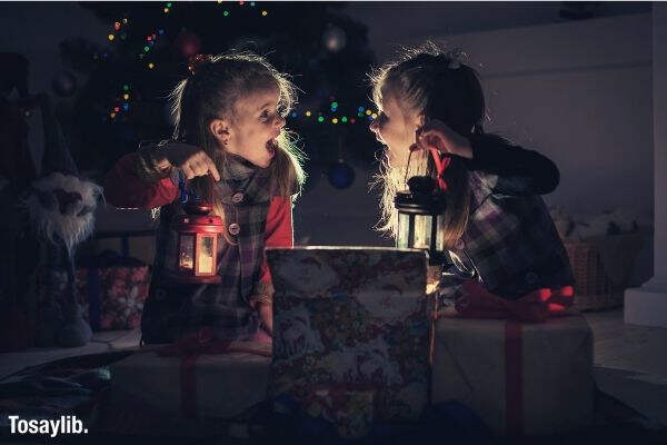 christmas night two girls open the gifts under the tree new years stories real emotions