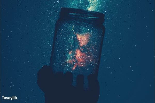 silhouette of person holding glass mason jar