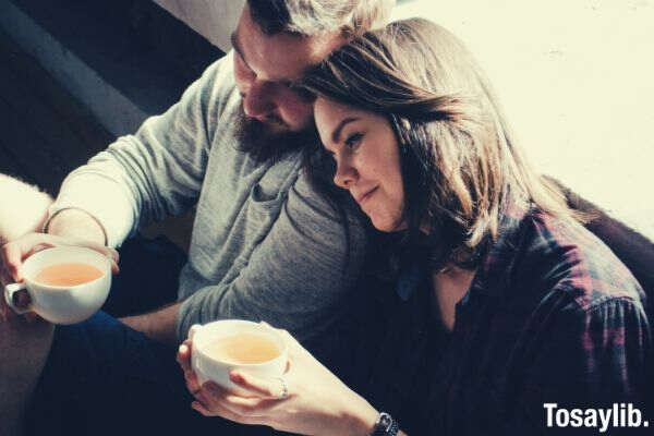 couple holding tea sitting