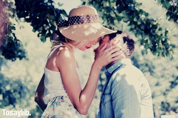 couple about to kiss sitting under tree