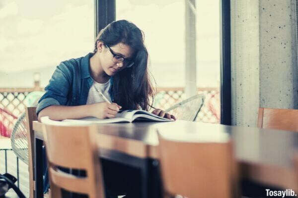 girl studying glasses writing pen table