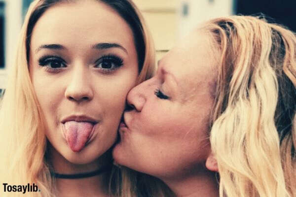 mother kissing daughter cheeks