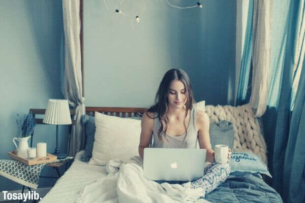 bedroom morning girl woman working from home millennial modern interior using technology