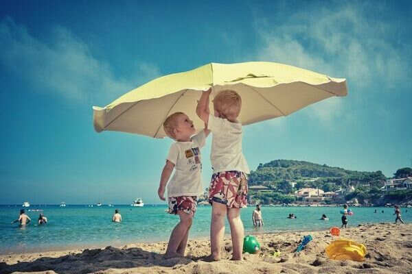 feature-two-kids-playing-under-the-umbrella-sand