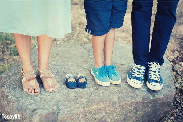 family feet closeup blue baby boy shoes