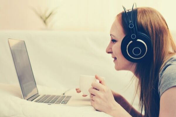 girl-listening-on-headphones-looking-computer