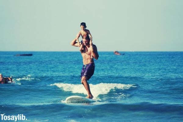 guy surfing with the kid