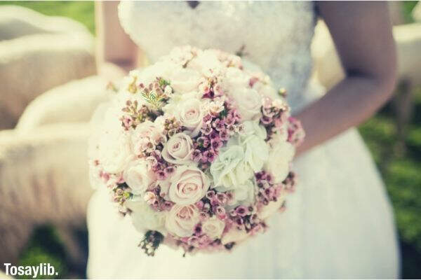 bride holding bouquet flowers wedding gown