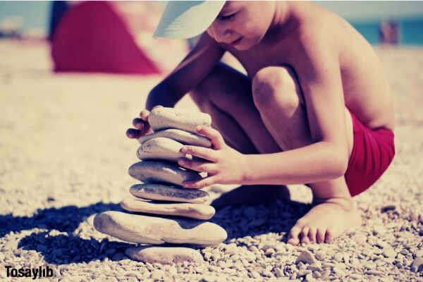 01 boy building stones on beach