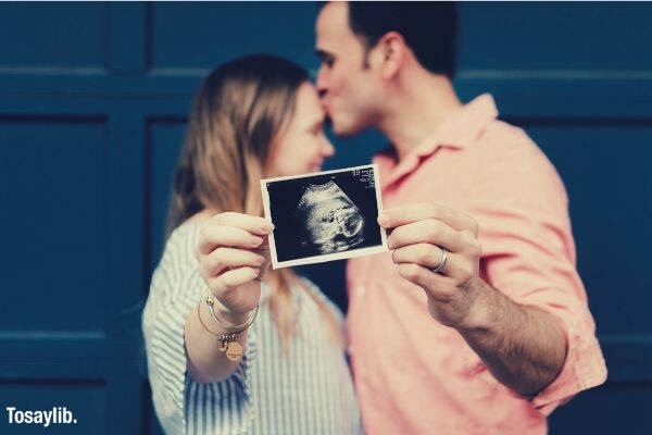 03 couple kiss forehead holding ultrasound picture