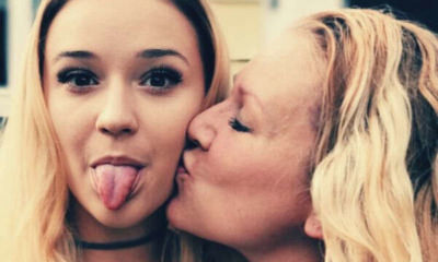 mother-kissing-daughter-cheeks-stick-tongue-out